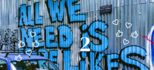 Ein Graffiti auf einer Wand, wo "All we need is likes" steht